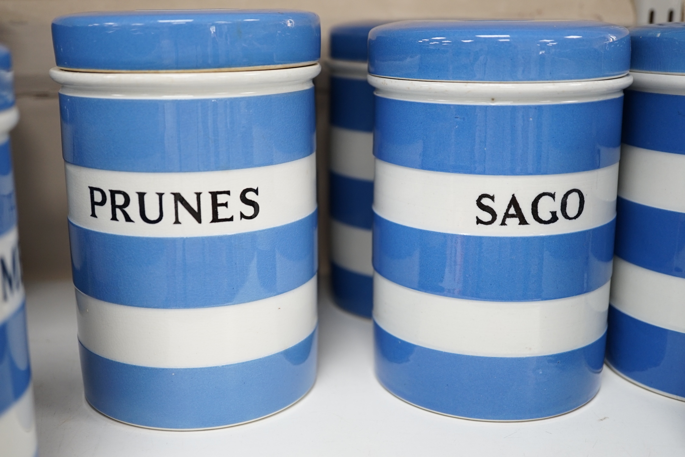 T.G.Green Cornish Kitchenware, nine 14cm lidded storage jars to include Custard Powder, Sago, Tapioca, Brown Sugar, Bread Crumbs and Prunes, Black Shield marks. Condition - fair to good